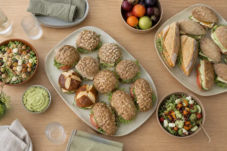 Schalen met verschillende belegde broodjes, salades en fruit
